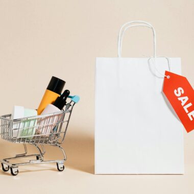 Minimalist image featuring a shopping cart with products and a sale-tagged bag.
